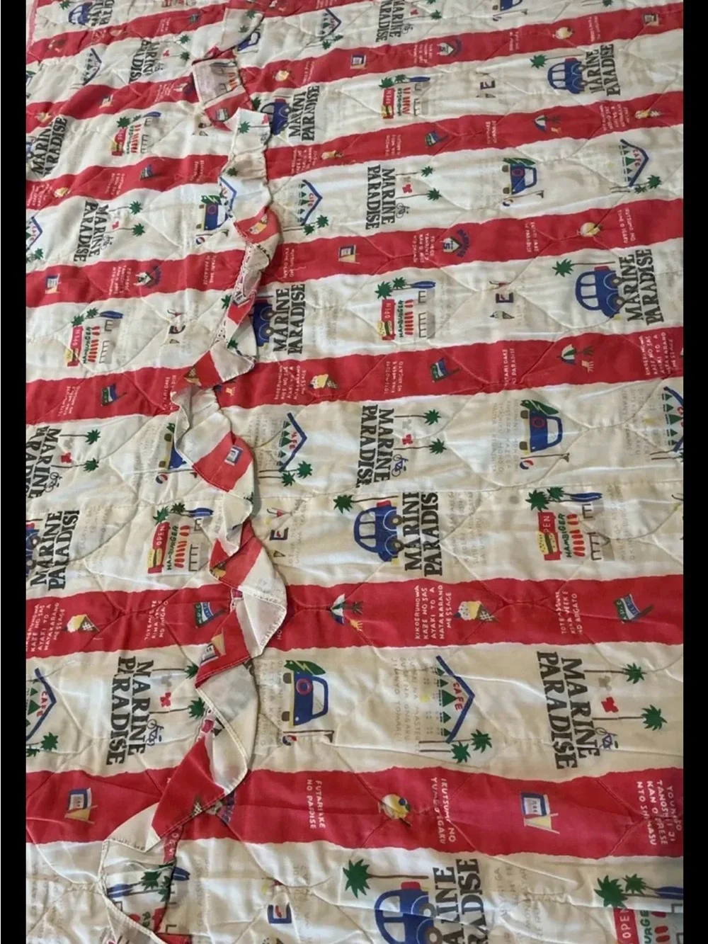 Vintage Marine Paradise quilted blanket featuring a colorful red and cream novel